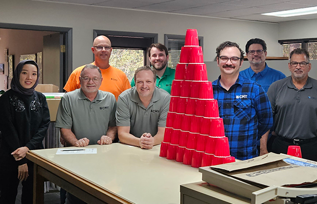 Jacksonville, FL, team posing as they work together to stack cups in challenge