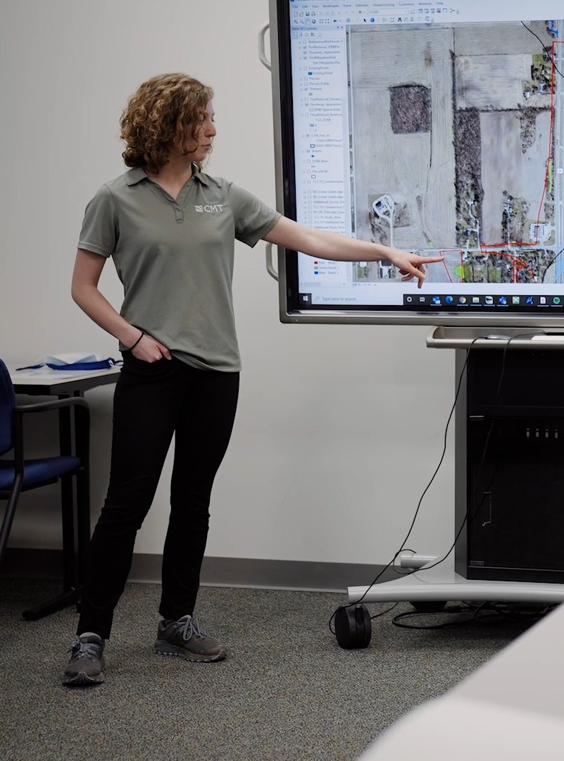 CMT Engineer and Consultant pointing to a presentation screen